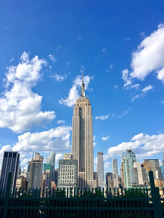 New York City, Circa 2017: Empire State Building view from Manhattan rooftop overlooking NYC skyline on clear day. Famous architecture landmarkのeditorial素材