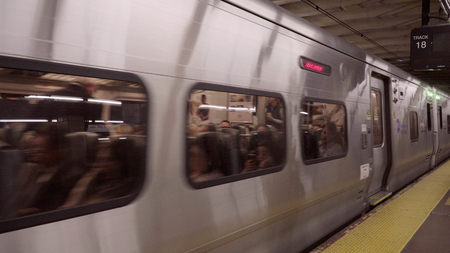 New York City - Circa 2017: LIRR Long Island Railroad train depart Penn Station platform underground midtown Manhattan NYC. Commuter passengers leave work traveling home to LIのeditorial素材
