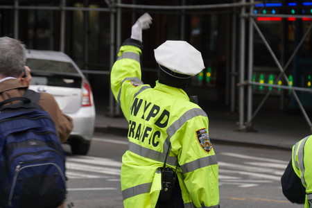 New York City - April 2016: NYPD police officer direct traffic during the busy morning commute in...