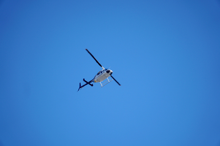 State Police helicopter hovering overhead providing aerial assistance to ground law enforcement personnelの写真素材