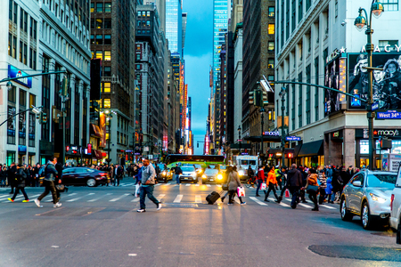 New York City - Circa 2017: View uptown 7th Avenue Manhattan during rush hour commute. People walking crosswalk street traffic wait red light. NYPD traffic officers direct car safety. Instagram filterのeditorial素材