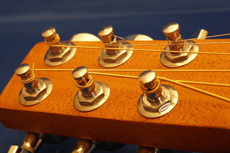Macro wood acoustic guitar head with six strings and tuning knobs.の写真素材