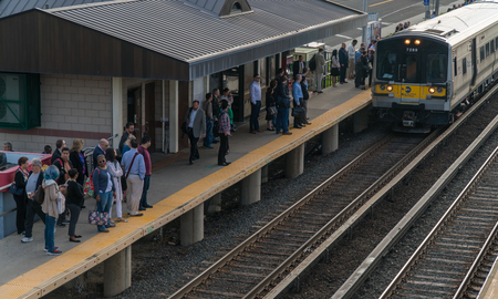 Long Island, NY - Circa 2017: Long Island Railroad LIRR train arrive local station platform to commute passengers travel Penn Station New York Cityのeditorial素材