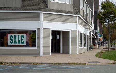 Day time exterior generic no signage retail clothing storefront on a main street in small town anywhere USA. People window shop up and down sidewalkの写真素材