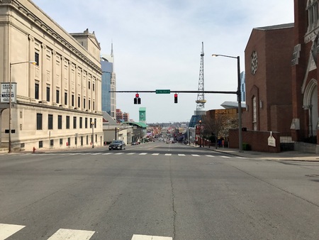 Nashville Tennessee - Circa 2017: Downtown strip country music row. Bars and restaurants line street with skyline background.のeditorial素材