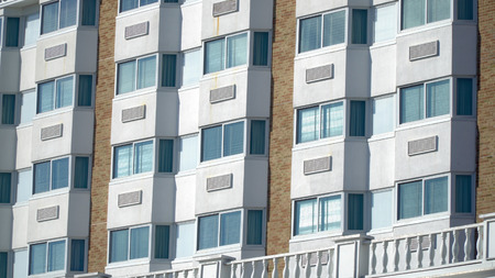 Establishing shot day time exterior close up hotel room window facade. Generic architecture design...