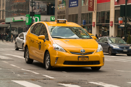 New York City - Circa 2017: Yellow taxi cab driving in streets of Manhattan on a busy day. Taking passengers to destinations around city. Hail cab or use mobile app to call Uber or Lyft.のeditorial素材