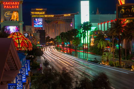 Las Vegas, USA - Circa 2017: Las Vegas Blvd long exposure light trails traffic driving on road past casino hotel row. Neon billboard signs illuminate the beautiful cityscape in desertのeditorial素材