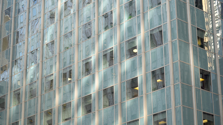 Day time exterior photo of green office building facade of glass and windows