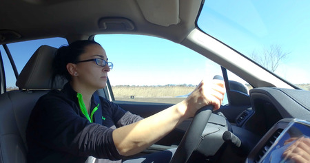 Attractive young woman side view driver on interstate highway through countryside during day time....