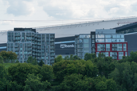 Minneapolis USA - Circa 2018: US Bank Stadium behind the Mississippi River waterfront skyline on a summer day. Home to Minnesota Vikings football team.のeditorial素材