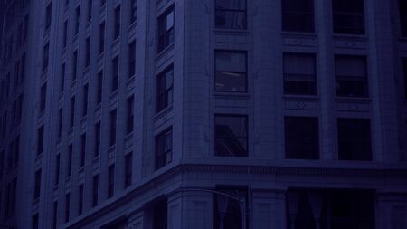 Night time establishing shot of generic typical urban city apartment or office building at night time under blue tint moon light.の写真素材