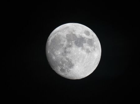 A beautiful close up view of the full moon on a clear night looking up vertical into spaceの写真素材