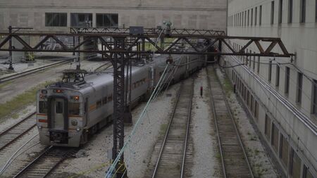 Overhead view of large passenger commuter train switching tracks through a railroad yard. Electric power locomotive use current from wires aboveの写真素材
