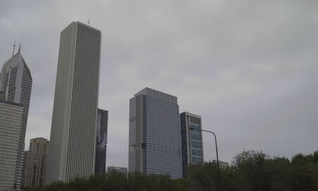 Day exterior urban city skyline generic view towers over tree line on overcast cloudy day.の写真素材
