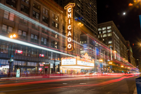 Chicago, IL - Circa 2019: Chicago landmark theatre famous venue in downtown. Night time exterior establishing shot long exposure of traffic light trails passing marquee lit up logo signのeditorial素材