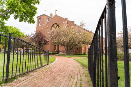 A generic church viewed through steel fence posts along beautiful landscaping design. Day time exterior concept photographyの写真素材