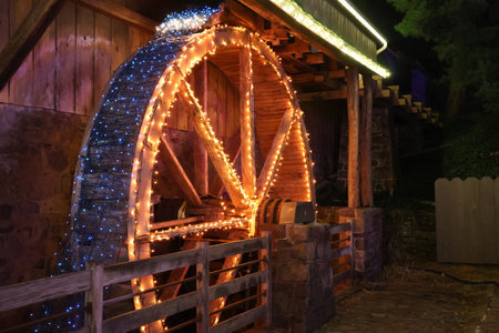 Old water mill at night with a garland of led lights.