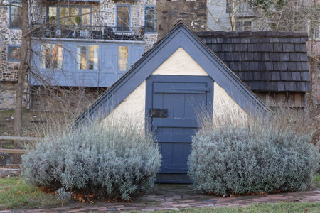 A house with a blue door and a flower bed in the foregroundの写真素材
