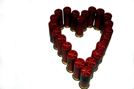Shotgun shells in the heart shape on whiteの写真素材