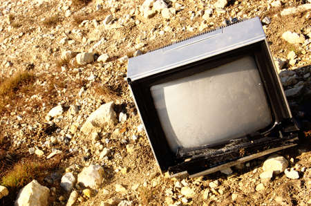 Broken television in fieldの写真素材