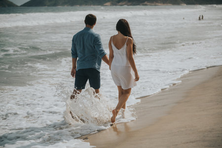 Couple in love walking on the beach. Young man and woman holding hands.の写真素材