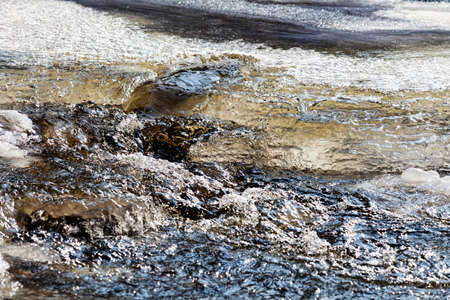 Frozen creek in winter forest landscapeの写真素材