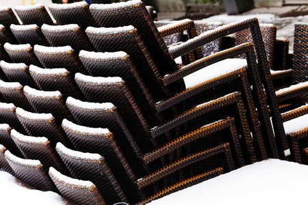 Stack of brown chairs infront restaurant; verticallyの写真素材