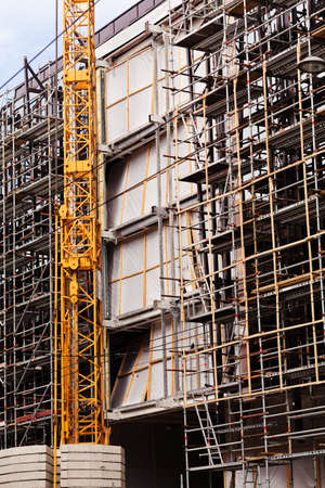 building under construction with scaffolding and crane