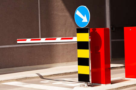 Entrance of parking, with barrier and mandatory way signの写真素材