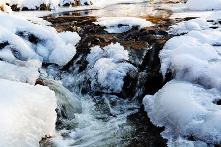 Small cascade in mountain stream, on winter dayの写真素材