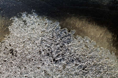 Crystals of ice on frozen creek water