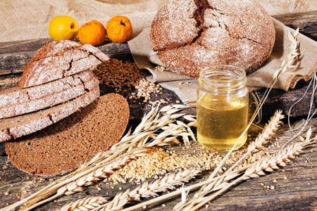 Rye wholemeal bread on a wooden board with olive oil and lemonの写真素材