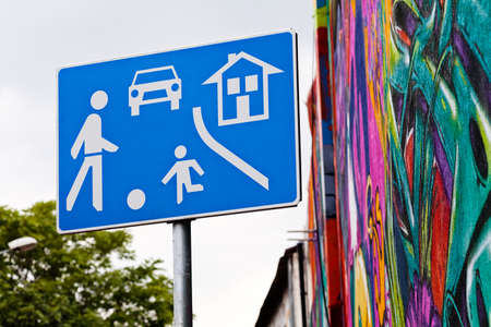 Blue residential area sign with sky and mural on the building in backgroundの写真素材