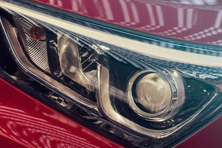 type  of headlights on the red car, note shallow depth of field