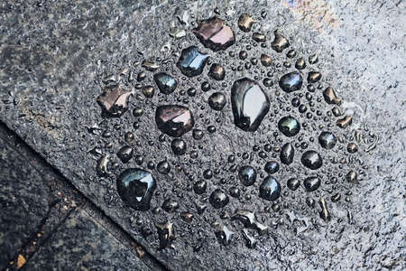Drops of water on the dark  pavement