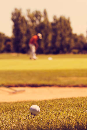 golfers on the golf course with trees around, note shallow depth of field