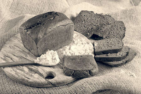 pieces of black bread on a round wooden boardの写真素材