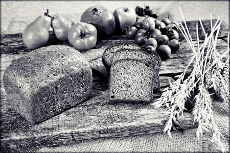 rye bread with seeds on a wooden board with a medlar and fruit around