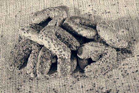 pastry with seeds in the shape of a horseshoe on a linen background
