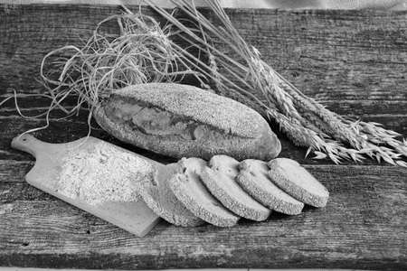 Decoration with rye bread, dried herbs and flour on a wooden base