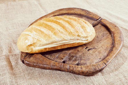 loaf of bread on an old wooden boardの写真素材