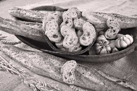 baguette on a wooden plate and pieces  of the basketの写真素材