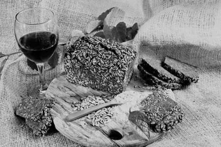 Decoration with black bread and red wine on the round wooden boardの写真素材