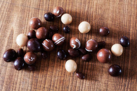 Round praline with white and dark chocolate on the wooden table, note shallow depth of fieldの写真素材