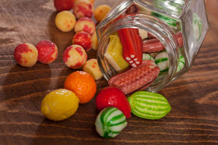 colorful hard candies in  a glass jaron the wooden table, note shallow depth of field