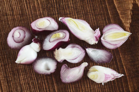 pieces of red onion on a wooden board, note shallow depth of fieldの写真素材