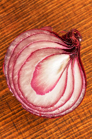 half of red onion on a  wooden board, note shallow depth of fieldの写真素材