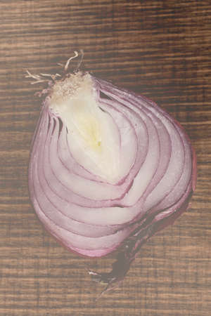 half of red onion on a  wooden board, note shallow depth of fieldの写真素材
