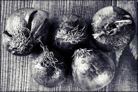 red onions on a  wooden board, note shallow depth of fieldの写真素材